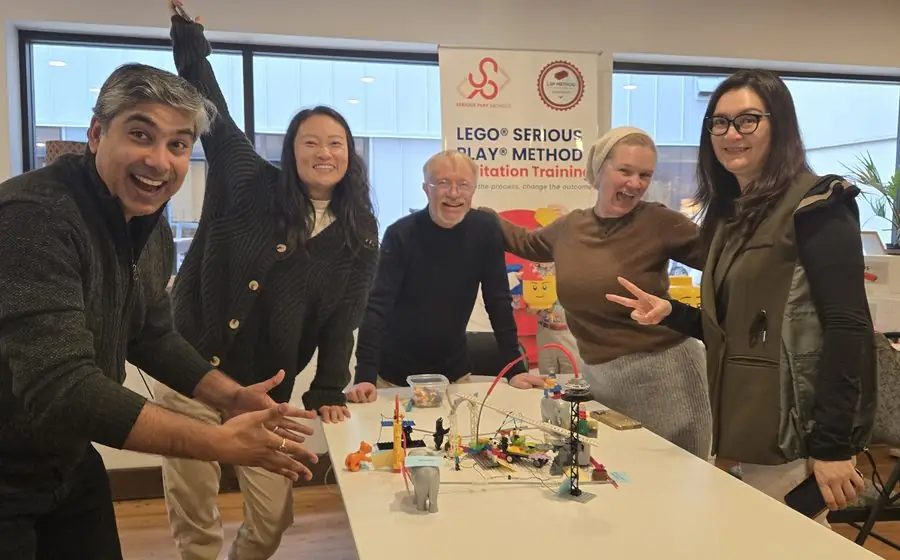 Participants celebrating around their LEGO landscape model during the November 2025 Vancouver cohort