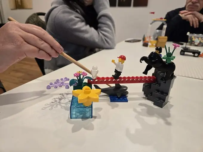 A participant pointing to part of a LEGO landscape model, with a bridge linking two builds